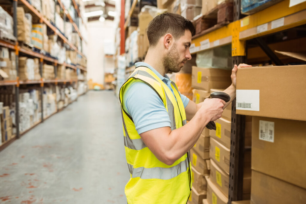 Agent d’inventaire scannant un carton en entrepôt