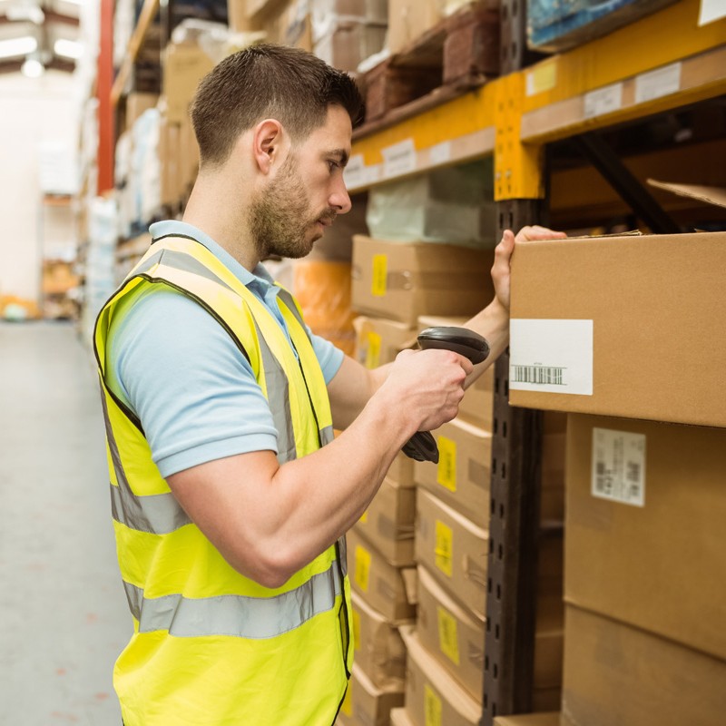 Agent d’inventaire scannant un carton en entrepôt